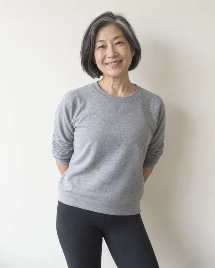 Mei Tanaka, a teacher in her fifties with a silver streaked bob and a grey sweatshirt, smiling